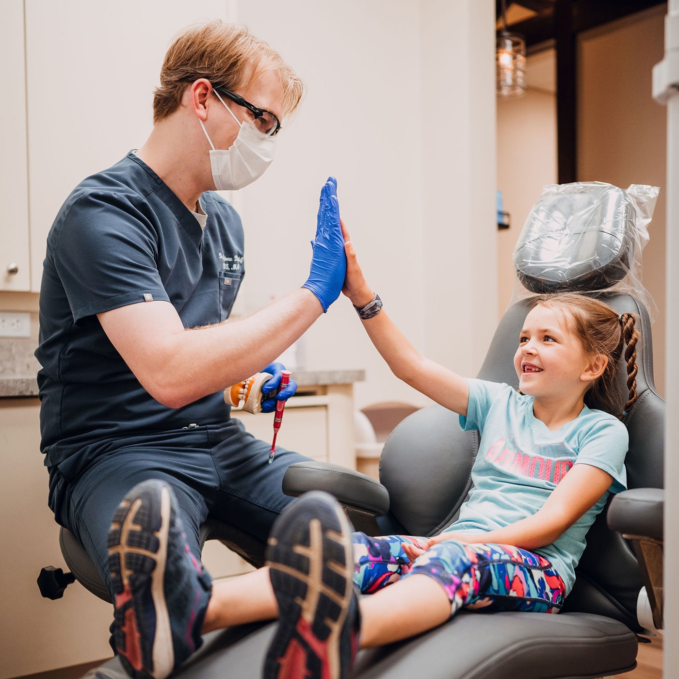 dentist giving young patient a hi five